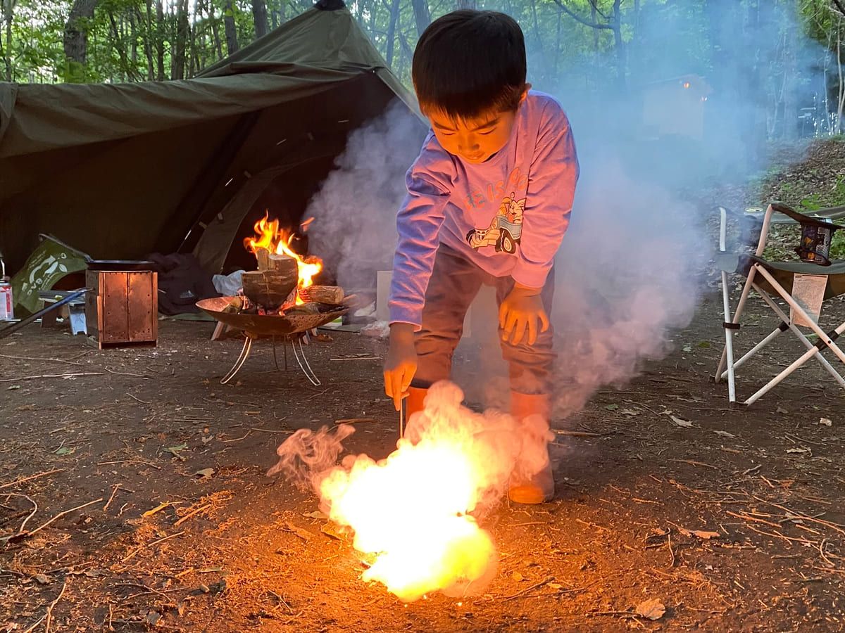 タープの前で手持ち花火をする子ども